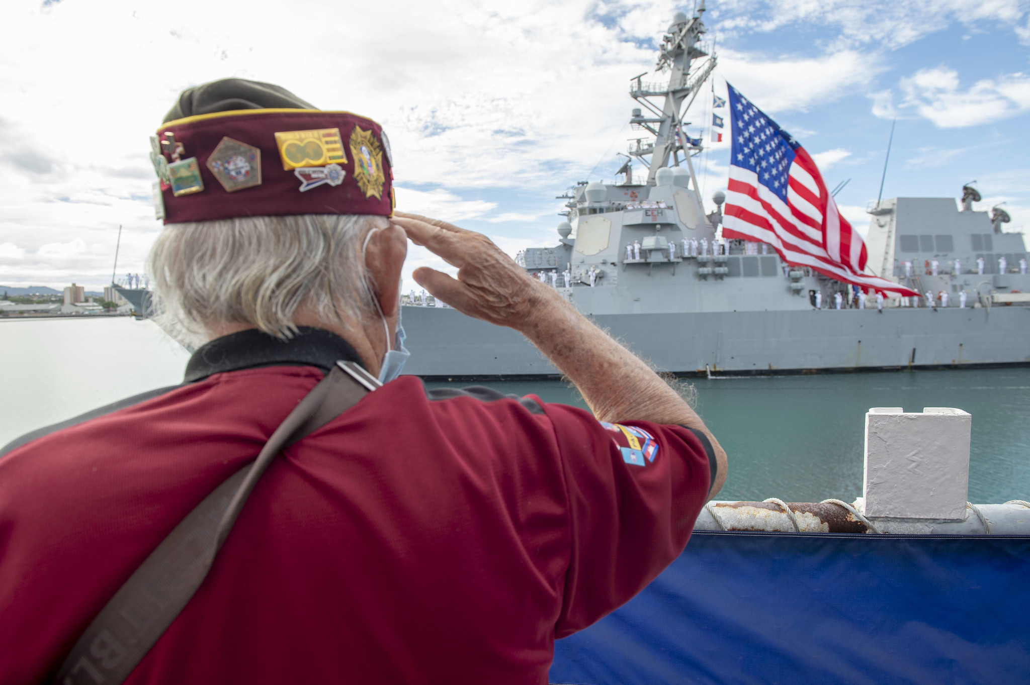 Military veteran Wendell Newman salutes the guided-missile destroyer USS Michael Murphy (DDG 112) during the pass in review portion of the 75th anniversary of the End of World War II commemoration ceremony at Pearl Harbor, Hawaii, Sept. 2, 2020.