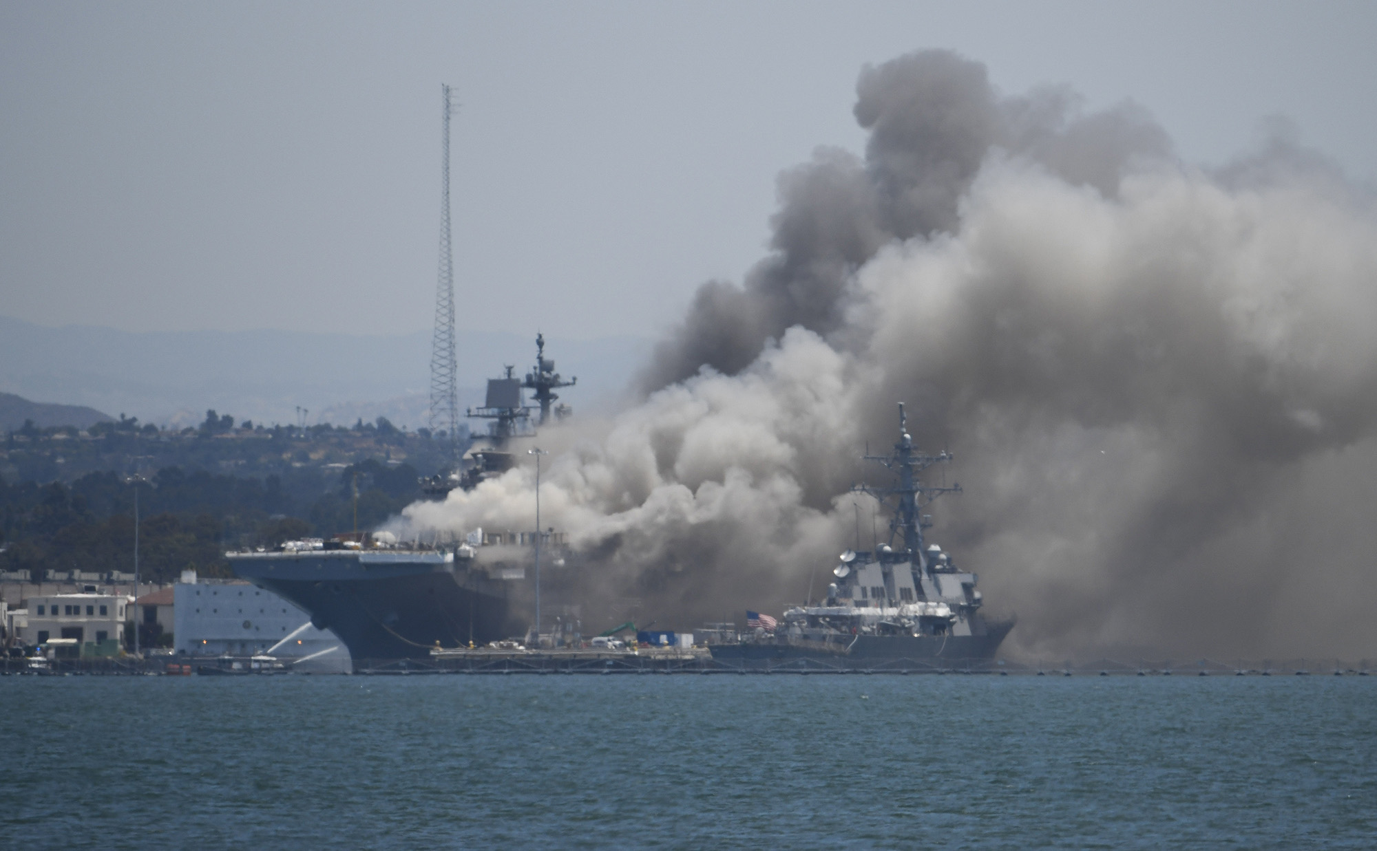 Smoke rises from the USS Bonhomme Richard at Naval Base San Diego Sunday, July 12, 2020, in San Diego after an explosion and fire Sunday on board the ship at Naval Base San Diego.