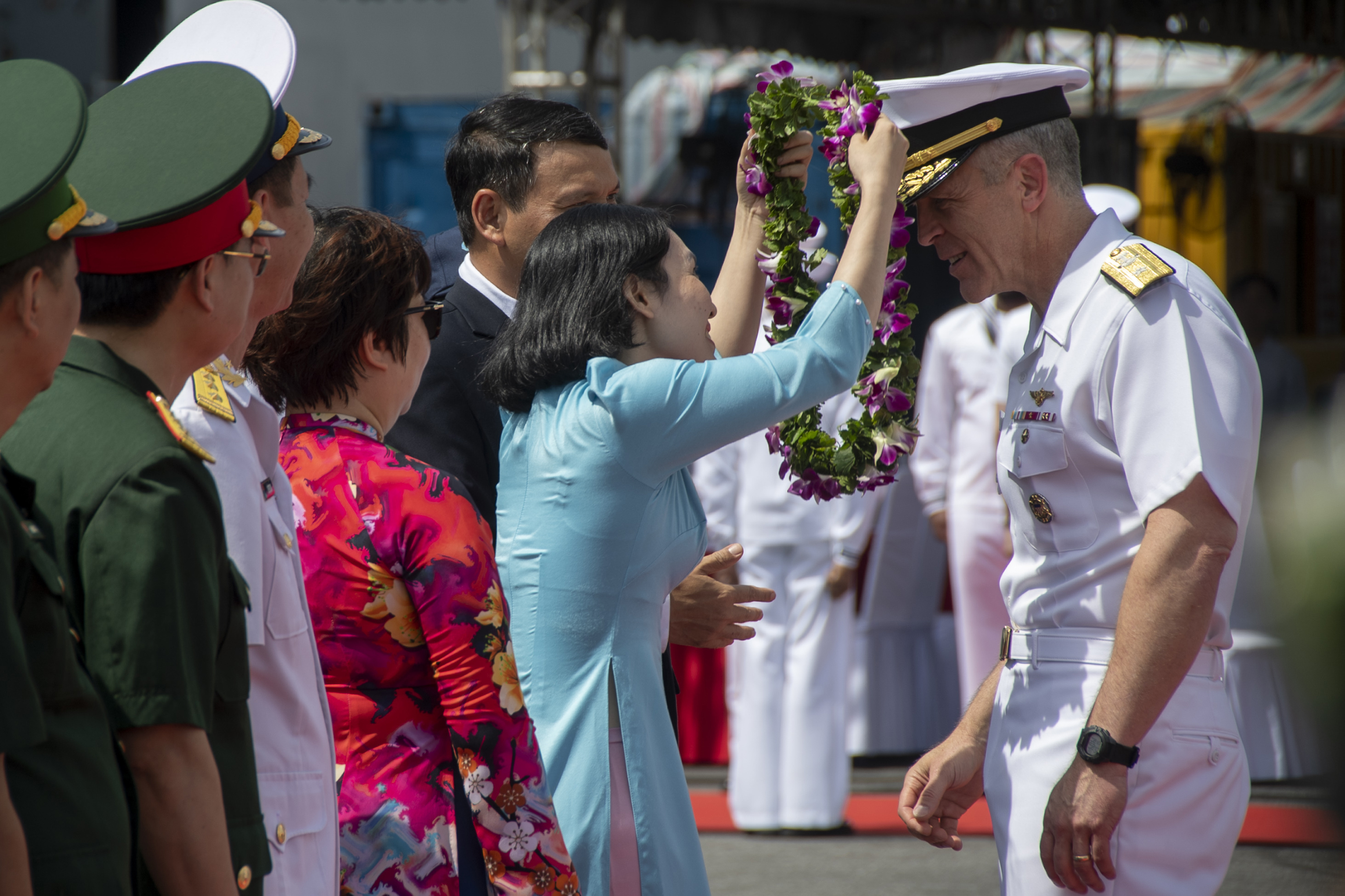 In this photo provided by U.S. Navy, Rear Adm. Pat Hannifin, right, receives a wreath during a welcome ceremony after the aircraft carrier Ronald Reagan, anchored into Da Nang, Vietnam, for a routine port visit, Sunday, June 25, 2023.
