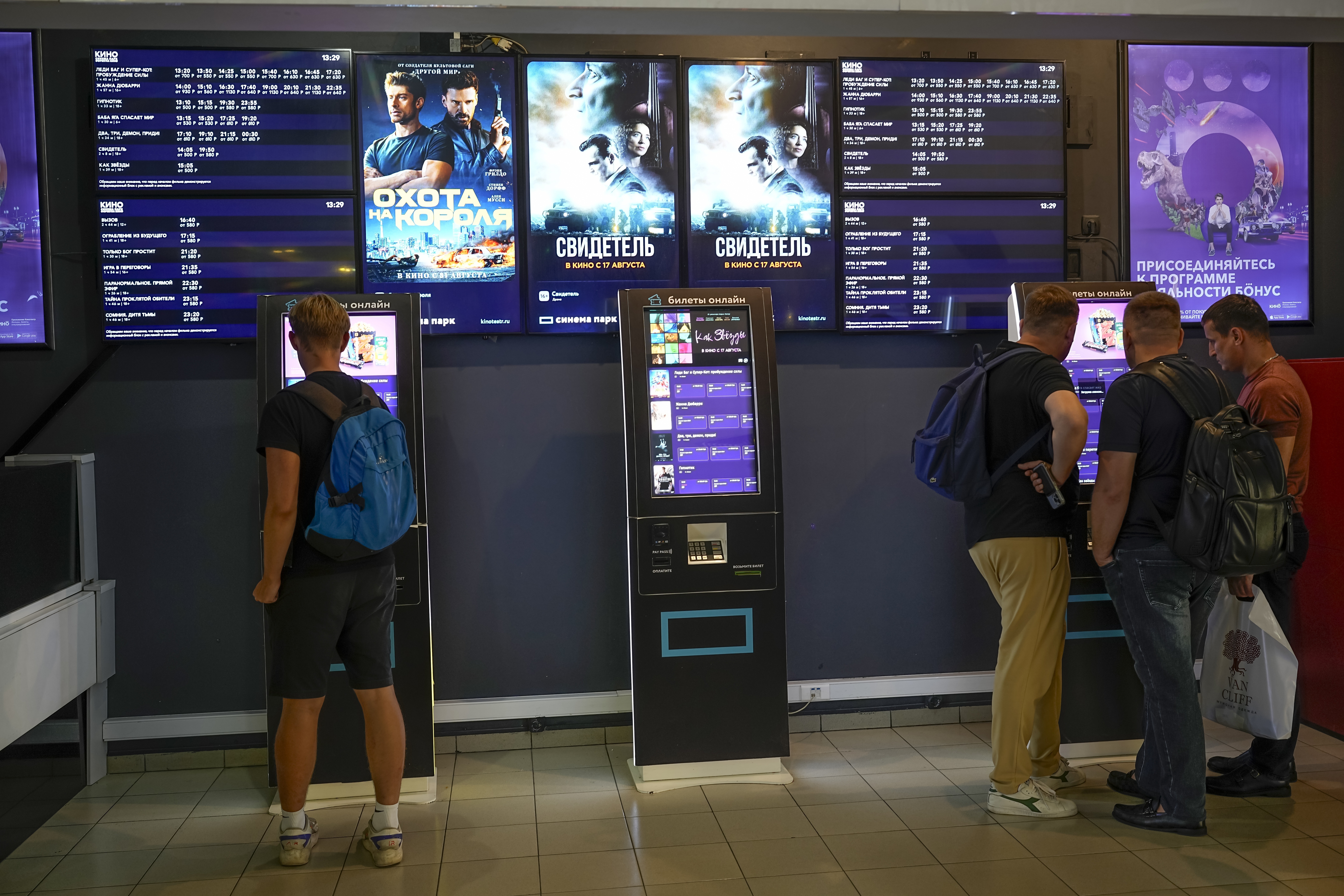 People stand at ticket machines in a cinema lobby inside a shopping mall in Moscow, Russia, Thursday, Aug. 17, 2023.