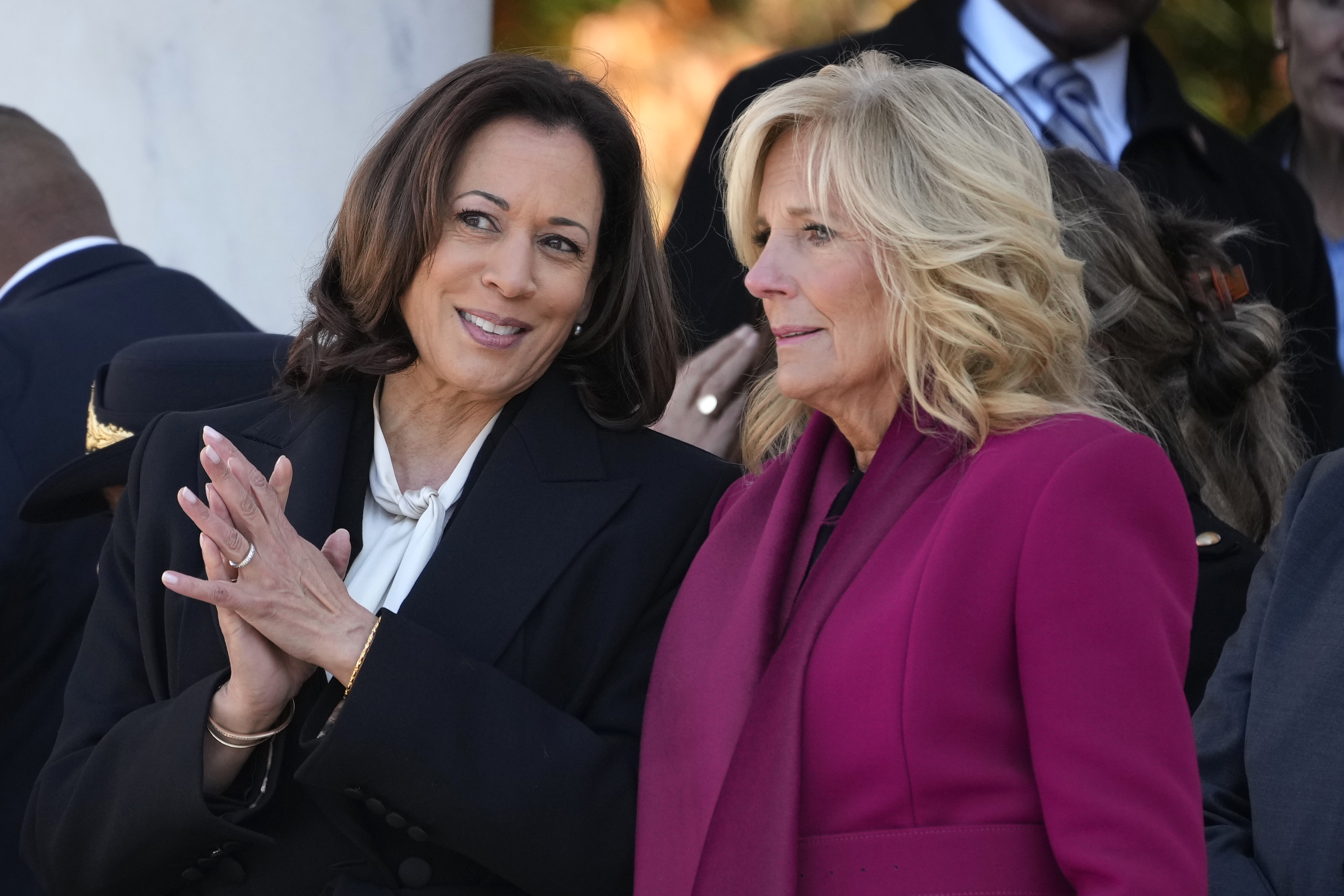 Vice President Kamala Harris talks with first lady Jill Biden before President Joe Biden speaks at the National Veterans Day Observance at the Memorial Amphitheater at Arlington National Cemetery in Arlington, Va., Saturday, Nov. 11, 2023.
